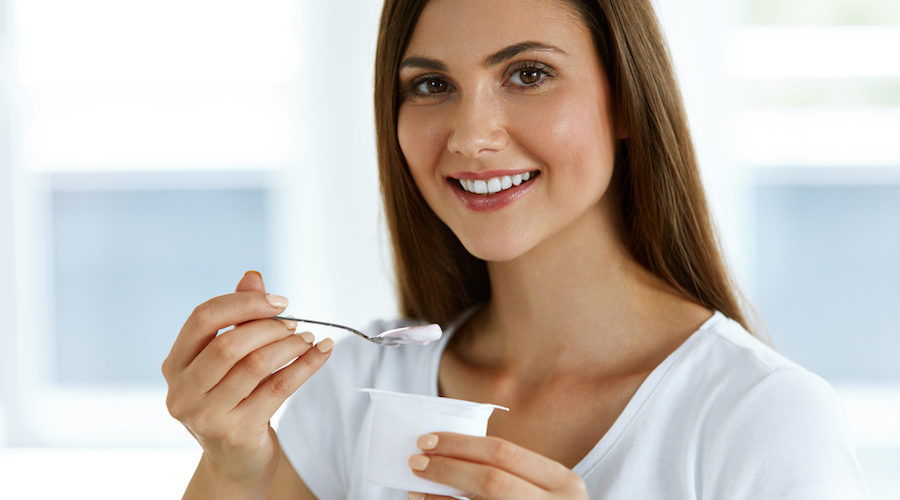 Beautiful Woman Eating Organic Yogurt. Healthy Diet Nutrition